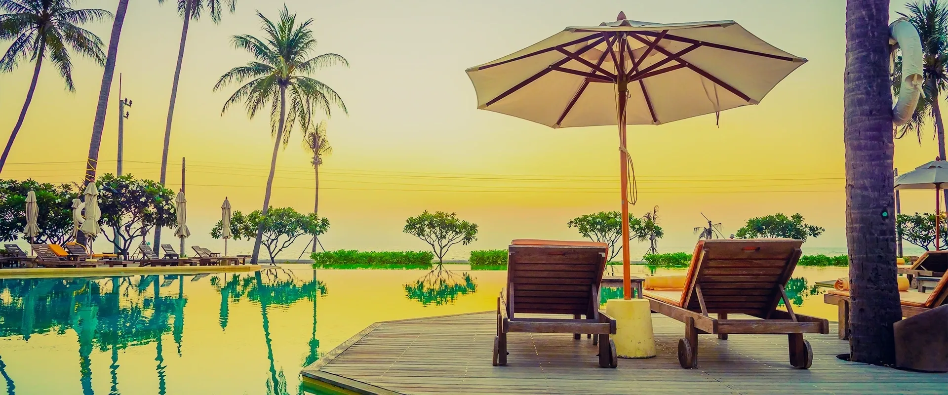 A deck with an umbrella and chairs on the side of it.