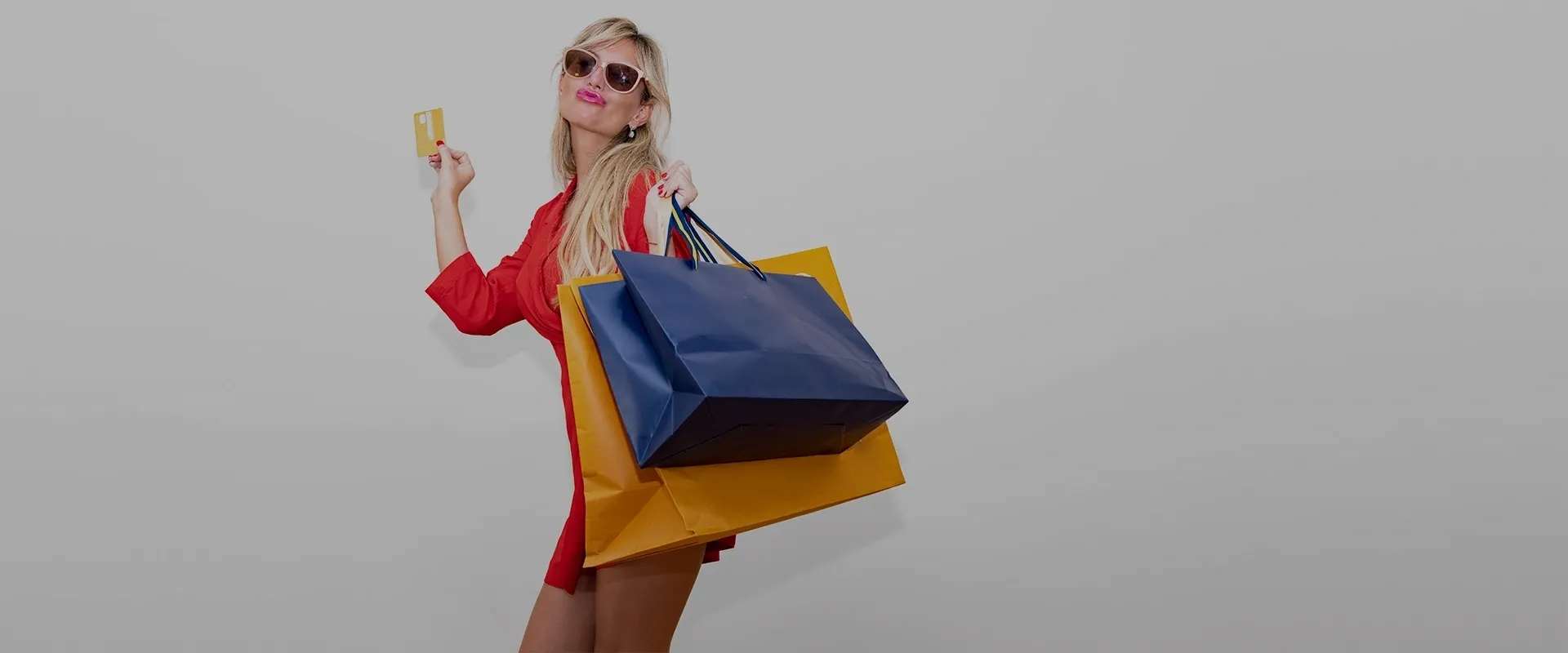 A woman in red shirt holding two bags.